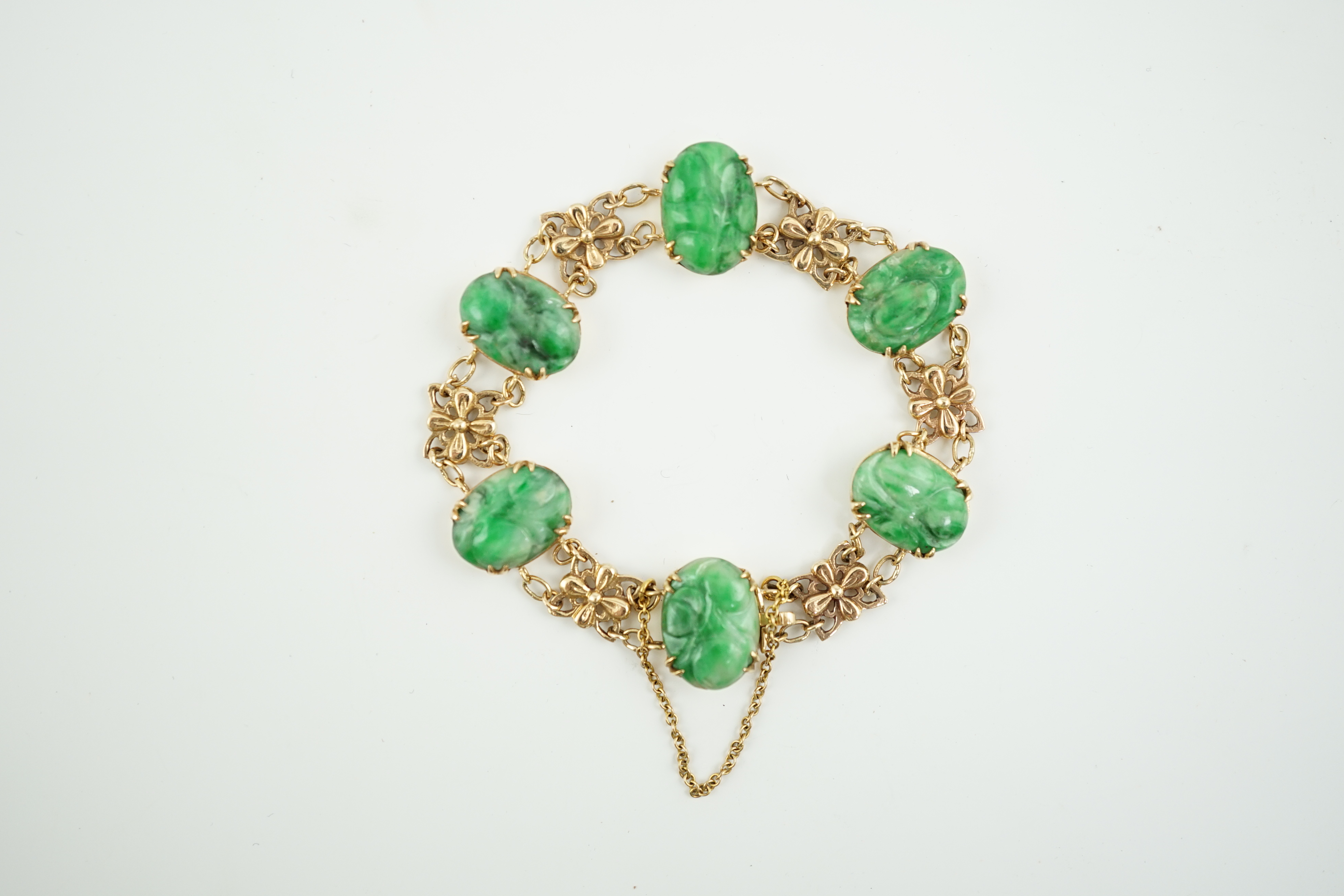 An early 20th century 9ct gold butterfly link and six stone carved jade set bracelet